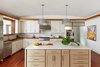 Custom white oak butcher block counters, herringbone Calacatta marble back splash, Calacatta Borgini Gold island with book matched waterfall panels, topped with a pair of Saturno Pendant Lamps by Kazuo Motozawa. Art is original oil on canvas by the client's uncle. Photo 11 of Lake Austin Remodel modern home