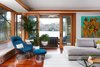 Modern home with Back Yard, Hardscapes, Large Patio, Porch, Deck, Landscape Lighting, Metal Fences, Wall, Ceiling Lighting, Recessed Lighting, Table, Sectional, Coffee Tables, Console Tables, Ottomans, Accent Lighting, Stools, Wood Patio, Porch, Deck, Decking Patio, Porch, Deck, Dresser, Undermount Sink, Alcove Tub, and Pendant Lighting. Vintage Platner high back lounge chair with ottoman, Thayer Coggin Mr. Big Sofa, vintage brass and glass top coffee table, rug from Black Sheep Unique and original art by Austin's own Patrick Puckett. Planters are by West Elm. Photo 13 of Lake Austin Remodel
