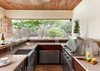 Modern home with Hardscapes, Ceiling Lighting, Back Yard, Metal Fences, Wall, Large Patio, Porch, Deck, Landscape Lighting, Recessed Lighting, Sectional, Coffee Tables, Ottomans, Table, Accent Lighting, Stools, Wood Patio, Porch, Deck, Decking Patio, Porch, Deck, Dresser, Undermount Sink, Two Piece Toilet, Chair, and Gas Burning Fireplace. Ipe clad custom outdoor kitchen with stainless steel cabinetry inserts by Lynx, with Lynx natural gas grill, with Cesarstone counters in linen. Bar top is local sandstone and barstools are by Janus Et Cie. Photo 17 of Lake Austin Remodel