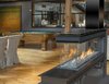Modern home with Living Room and Gas Burning Fireplace. Tell us about the fabrication of the fireplace hearth.
We worked with a really skilled metal fabricator — Fortin Ironworks. We have worked with them for years and years now. They do great iron work and are very old school in their approach. The best part is, they truly love doing what they do. We actually had the fireplace shipped right to them so they could custom create the hearth for us.
A lot of the original industrial details from this space are still present and some new elements are added, such as that I-beam hearth. Why was it important for you to keep this industrial aesthetic?
The building itself is what we originally fell in love with. It was so unique and we wanted to bring out its inner character. I’d say in general, I gravitate to more imaginative spaces. Photo 2 of Buggy Works