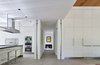 Modern home with Kitchen, Microwave, Cooktops, Ceiling Lighting, Porcelain Tile Floor, Range Hood, Dishwasher, Undermount Sink, Wall Oven, Refrigerator, White Cabinet, Engineered Quartz Counter, and Mirror Backsplashe. Entry, kitchen, dining. Photo 3 of The TORO House