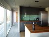 Modern home with Kitchen, Medium Hardwood Floor, Wood Counter, Laminate Cabinet, Mirror Backsplashe, Ceiling Lighting, Recessed Lighting, Refrigerator, Cooktops, Range, Dishwasher, and Drop In Sink. Kitchen Photo 8 of Little Box on the Prairie