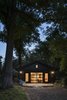 Modern home with Concrete Siding Material, House Building Type, Back Yard, Trees, Living Room, and Concrete Floor. SvartKub lights up in the evening. Photo of SvartKub