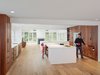 Modern home with Kitchen, Engineered Quartz Counter, White Cabinet, Wood Cabinet, Recessed Lighting, Undermount Sink, and Light Hardwood Floor. Custom cabinetry using Reclaimed American redwood with integrated pulls. Photo of Wayne Residence