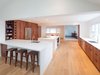 Modern home with Kitchen, Refrigerator, Engineered Quartz Counter, White Cabinet, Cooktops, Wood Cabinet, Light Hardwood Floor, Recessed Lighting, and Undermount Sink. contrasting high gloss quartz counters with reclaimed American redwood cabinet fronts Photo 4 of Wayne Residence