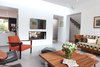 Modern home with Living Room, Wood Burning Fireplace, Recessed Lighting, Chair, Concrete Floor, Two-Sided Fireplace, Sofa, and Coffee Tables. The living room replaces the courtyard Photo 5 of Extension of a house in Geneva