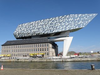 With 12 kilometers of docks, Antwerp is Europe’s second largest shipping port, serving 15,000 sea trade ships and 60,000 inland barges each year. The new Port House in Antwerp repurposes, renovates, and extends a derelict fire station into a new headquarters for the port—bringing together the port’s 500 staff members that previously worked in separate buildings around the city. The facade’s rippling quality is generated with flat facets to the south that gradually become more three-dimensional towards to the north. This perception of a transparent volume, cut to give the new building its sparkling appearance, reinterprets Antwerp’s moniker as the city of diamonds.