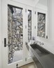 Modern home with Bath Room, Concrete Counter, Medium Hardwood Floor, Concrete Floor, Wall Mount Sink, Open Shower, and Stone Slab Wall. A stone wrapped outdoor shower in the second bath. Photo 8 of The Lighthouse
