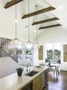 Modern home with Kitchen, Wood Cabinet, Concrete Counter, Medium Hardwood Floor, Recessed Lighting, Ceiling Lighting, Pendant Lighting, Accent Lighting, Refrigerator, Wall Oven, Cooktops, Microwave, Dishwasher, Wine Cooler, and Undermount Sink. Kitchen looking into the dining and out towards the Atlantic Ocean. The collar ties are exposed to express the homes structural integrity and bring down the scale of the space Photo 5 of The Live Oak House