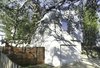 Modern home with Exterior, House Building Type, Green Roof Material, Wood Siding Material, and Stucco Siding Material. South Side/Garage-The home is designed as a U-Shape creating a courtyard around the large Live Oak Tree. The site is designed to absorb 100% of the water that falls on the site. Photo 4 of The Live Oak House
