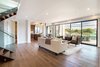Modern home with Living Room, Chair, Medium Hardwood Floor, Two-Sided Fireplace, Sofa, and Ceiling Lighting. Entry and living room. Photo of The Abernathy