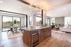 Modern home with Marble Counter, Wood Cabinet, Medium Hardwood Floor, Beverage Center, Undermount Sink, Ceiling Lighting, Dining Room, Table, and Chair. Kitchen island and dining area Photo 7 of The Abernathy