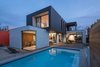 Modern home with Outdoor, Back Yard, Large Pools, Tubs, Shower, Wood Patio, Porch, Deck, Large Patio, Porch, Deck, Hardscapes, Wood Fences, Wall, Horizontal Fences, Wall, Concrete Patio, Porch, Deck, Concrete Pools, Tubs, Shower, and Swimming Pools, Tubs, Shower. Minarc’s outside-in, inside-out ethos guides them to holistically incorporate eco-conscious practices into every project. The Drexel Residence features sliding walls of glass that lead from the kitchen to a breezeway that serves as the alfresco dining room, extending the home’s footprint to the outdoors and blurring the distinction between inside and out. Photo of Drexel Residence