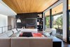 Artistically composed cabinets, shelving, TV, and fireplace create a focal point adjacent to the views of the golf course. Photo 2 of Modern Golf Course Home modern home