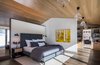 Modern home with Bedroom, Bed, Bookcase, Pendant Lighting, Dark Hardwood Floor, and Night Stands. Instead of a basic doorway between the master bedroom and bath, we designed a divider wall that visually enlarges the space. Photo 9 of Modern Cabin