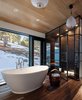 Modern home with Bath Room, Medium Hardwood Floor, and Pendant Lighting. The large floating bathtub invites relaxation and serenity. Photo 11 of Modern Cabin