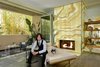 Chad Rogers and his Chihuahua Starla in front of a custom vanilla Onyx fireplace in the living room of his newly renovated Beverly Hills condo. Photo of Rogers Residence modern home