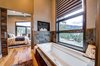 A wall lightswitch operates the LED candles in nooks flanking the air massage tub by Kohler Photo 18 of Ascent Estes Park modern home