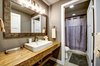 The downstairs hall bath mixes textures with Parallam countertops, concrete floors and warming gray textiles. Photo 11 of Ascent Estes Park modern home
