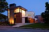 Modern home with Exterior, House, Wood Siding Material, and Flat RoofLine. The design provides a layer of privacy for the homeowners, while the solid massing peels away to large expanses of glazing, framing intended view sheds both inward and outward. Along with its verticality, the home pulls key horizontal elements from the established neighborhood rhythm, specifically the eaves and elevated floor lines. Photo of City Cottage