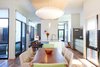 Modern home with Medium Hardwood Floor, Ceiling Lighting, Windows, Table, and Picture Window Type. The visual openness and centralized courtyard blur the boundaries of exterior and interior, which creates a peaceful respite within the urban setting. Photo 3 of City Cottage