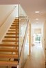 Modern home with Staircase, Wood Tread, and Glass Railing. Once inside the home, you are greeted in the entry hall immediately exposing to view a three-story stairwell incorporating a glass wall running the entire height. This first impression informs all visitors that this is not an old farmhouse. It was a deliberate juxtaposition to create a more contemporary and modern interior element as the unexpected design moment for this classic dwelling. Photo 3 of Urban Farmhouse