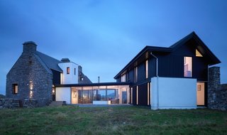 The White House was originally built in the mid-1700s on the Isle of Coll, but was subsequently abandoned for over 150 years. With only ruins remaining, the owners enlisted WT Architecture to complete a renovation that would incorporate what was left of the former structure with a modern and low-impact home. The result is a stunning mix of the original stone facade with new large windows that frame the ocean view. 