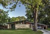 Modern home with Exterior, House Building Type, Metal Roof Material, Wood Siding Material, Glass Siding Material, Stone Siding Material, Shed RoofLine, and Mid-Century Building Type. The renovation literally raised the roof, increasing the interior ceiling height and allowing for the addition of clerestory windows. Photo 3 of Re-Open House