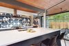 Modern home with Kitchen, Refrigerator, Cooktops, Range, Range Hood, Wood Cabinet, Concrete Floor, Colorful Cabinet, Ice Maker, Dishwasher, Recessed Lighting, Undermount Sink, Ceramic Tile Backsplashe, and Engineered Quartz Counter. The tongue-and-groove wood ceiling continues right out to the soffit. The beautiful graphic cement tiles from Cle carry over into the outdoor patio, further blending the indoor and outdoor spaces. Photo 9 of Re-Open House