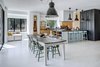 Modern home with Dining Room, Pendant Lighting, Light Hardwood Floor, Stools, Chair, Bar, Storage, and Table. A dead tree on the lot was milled to construct the dining table, further connecting the newly designed home to its historic community. Photo 9 of Mullet House