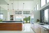 Modern home with Kitchen, Refrigerator, Dishwasher, Stone Slab Backsplashe, Engineered Quartz Counter, Pendant Lighting, Drop In Sink, Microwave, Wood Cabinet, Cooktops, Range, Ceiling Lighting, Recessed Lighting, Wine Cooler, and Wall Oven. Via Media Residence by Matt Fajkus Architecture | Photo by Leonid Furmansky Photo 9 of Via Media Residence