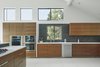 Modern home with Kitchen, Dishwasher, Microwave, Refrigerator, Engineered Quartz Counter, Wall Oven, Drop In Sink, Wood Cabinet, Stone Slab Backsplashe, Pendant Lighting, Ceiling Lighting, Wine Cooler, Range, Cooktops, and Recessed Lighting. Via Media Residence by Matt Fajkus Architecture | Photo by Leonid Furmansky Photo 10 of Via Media Residence