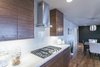 simple and clean cabinets compliment the wood floors and a consistent white counter and backsplash create a seamless flow. Photo 10 of King of the Wasatch modern home