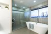 The master bathroom has been fully reworked to capitalize on the sweeping views that can be seen not just from the master bedroom but out the window perched directly above the soaking tub. Photo 4 of King of the Wasatch modern home