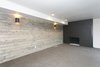 Basement Family room with wood accent wall and painted black brick fireplace. Photo 2 of King of the Wasatch modern home