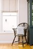 Modern home with Kitchen, Medium Hardwood Floor, and Colorful Cabinet. A vintage chair in a pefect location for one to sit and watch the birds enjoy the homemade birdhouses that decorate the fence outside. Photo of Going Old School in The Bay Area