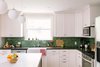 Modern home with Kitchen, Marble Counter, Engineered Quartz Counter, White Cabinet, Light Hardwood Floor, Wood Cabinet, Medium Hardwood Floor, Ceiling Lighting, Subway Tile Backsplashe, Recessed Lighting, Pendant Lighting, Refrigerator, Range Hood, Wall Oven, Microwave, Dishwasher, and Undermount Sink. The bold green tile adds a vibrant touch to the home, mirroring the client's personality. Photo 15 of Going Old School in The Bay Area