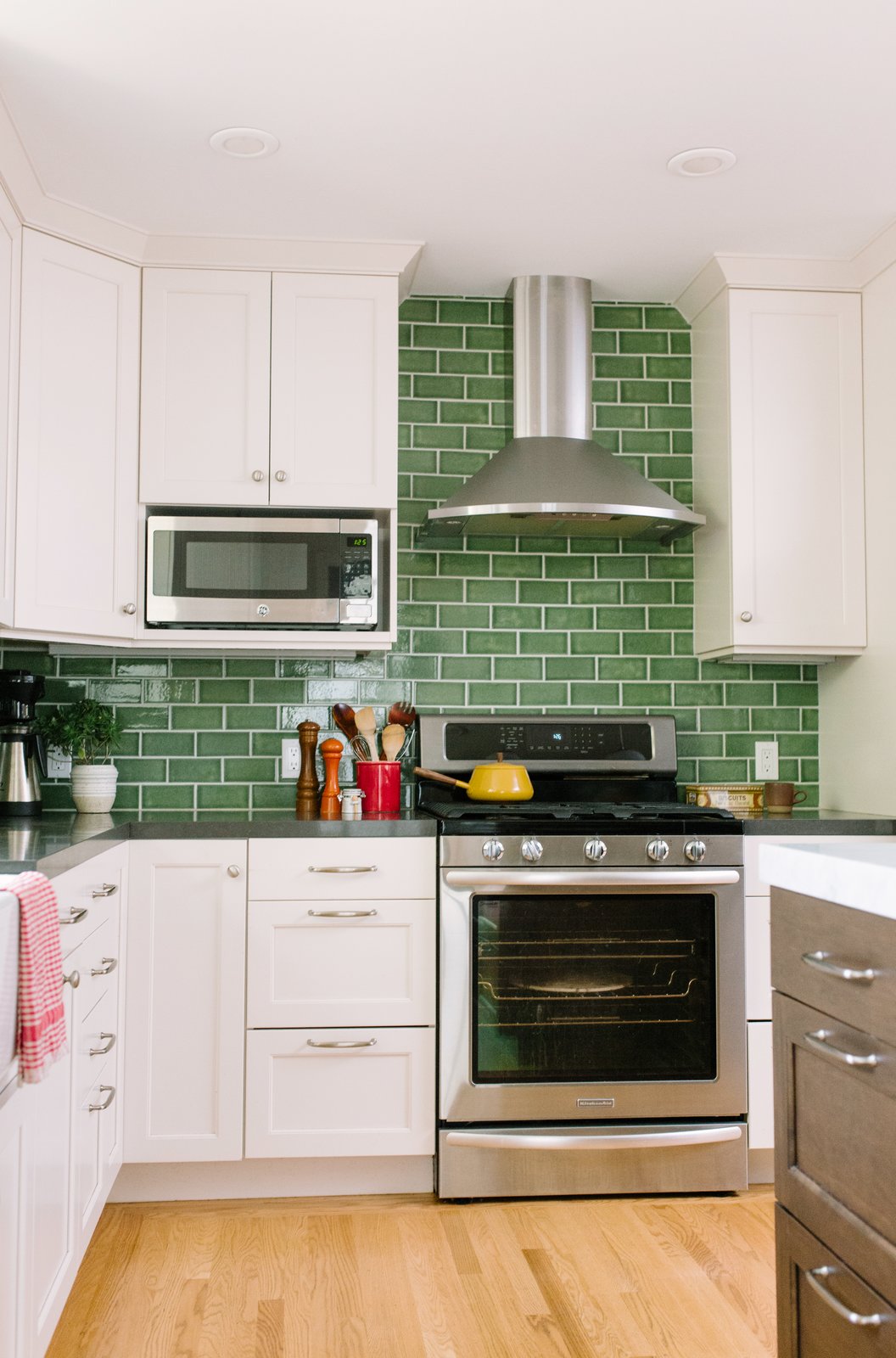 Fireclay Tile in a classic subway pattern goes beyond the standard 18" H backsplash raising the ceiling visually.