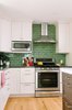 Modern home with Kitchen, White Cabinet, Stone Counter, Subway Tile Backsplashe, and Recessed Lighting. In this kitchen with white cabinets, Fireclay Tile in a classic subway pattern go beyond the standard 18" high backsplash, which brings the eye up the walls of the kitchen. The gloss of the tiles allows light to reflect throughout the space, keeping it bright and cheery despite the darker color. Photo 12 of Going Old School in The Bay Area