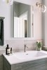 Modern home with Stone Counter, Drop In Sink, Enclosed Shower, Undermount Tub, Marble Floor, Ceiling Lighting, Marble Wall, and Wall Lighting. A clean vanity mirror from the exterior but on the interior, outlets keep electric items off of the countertop and tucked away. Photo 9 of Catching Waves In San Francisco