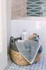 Modern home with Marble Floor, Stone Counter, Enclosed Shower, Drop In Sink, Ceiling Lighting, Undermount Tub, Wall Lighting, Recessed Lighting, Stone Tile Wall, Mosaic Tile Wall, and Marble Wall. The addition of a basket brings warmth, texture, and additional storage to a small bathroom, Photo 13 of Catching Waves In San Francisco