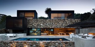 Stone walls surround the patio area and the edge of the pool.