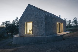 A stepped concrete roof continues the varied texture of the house's exterior.