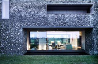 A dark, almost black mortar on the lower portion of the home makes it feel grounded in the landscape.