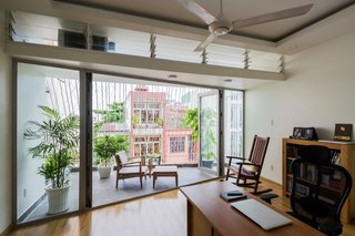 In this house in Thailand by Mel Schenck, a light shelf with translucent louvers above helps to regulate the bright light that enters from the outside porch.