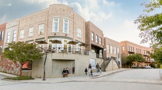 Housing includes loft-like apartments and townhouses in a range of traditional styles with double-hung, operable windows and brick facades.