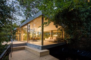 Inspired by the surrounding landscape of chestnut trees, rocky hillside, and bubbling stream, Portuguese architecture firm 3r Ernesto Pereira chose to blend into, and take advantage of, the local geography rather than fight against it at this sleek, modern home near the coastal city of Porto. At a cost of €100,000 (approximately $125,000) and measuring about 140 square meters, this stunning, wood-and-glass retreat took about four months to construct. 