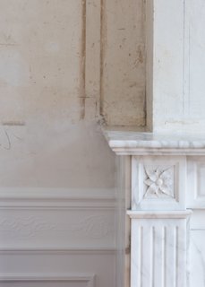 A detail of the historic marble fireplace and original plaster in the more formal rooms that look out onto the street. 