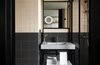 Modern home with Bath Room, Wall Mount Sink, and Drop In Sink. A bathroom in a guest room features a new take on traditional square two-tone tiles. Photo 9 of PURO Kraków Kazimierz