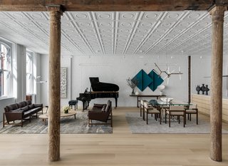 After architect Andrew Berman renovated a 2,800-square-foot, two-bedroom SoHo loft, designer Justin Charette fitted out the interior with minimalist furnishings and built-ins to complement the landmark building’s industrial and historical features—including a pressed tin ceiling and exposed wood beams. Designed as a pied-à-terre for a bicoastal client, the converted loft retains its high ceilings and tall windows that flood the open-plan interior with natural light while introducing a more streamlined aesthetic that includes a neutral palette of white oak, exposed brick walls painted white, and sleek contemporary furnishings—many of which were sourced from local New York designers and makers.